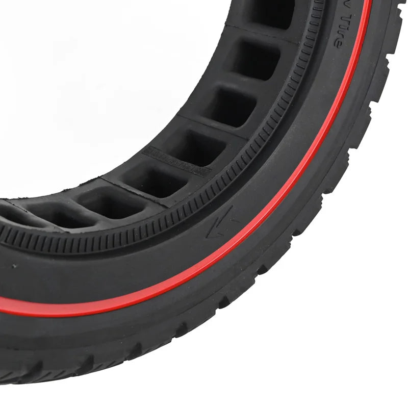 Close-up of a black tire with red rim on a white background