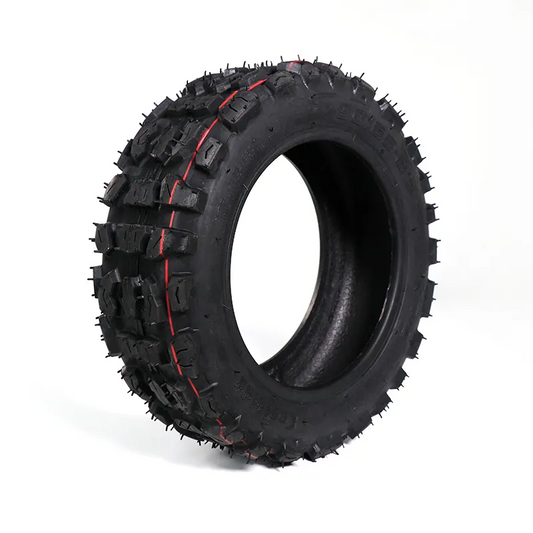 Black off-road tire with red accents on a white background