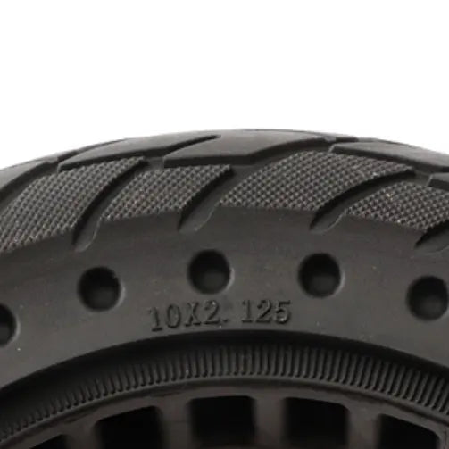 Close-up of a black tire with tread pattern and size marking on a white background