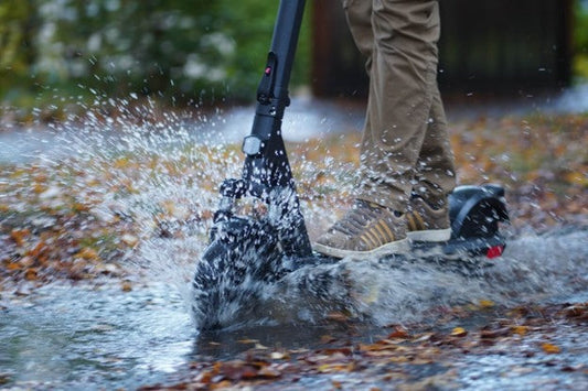 E-scooter riding through puddle on rainy day