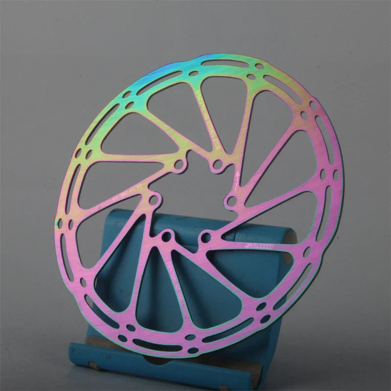 Multicolored metallic disc brake rotor on a gray background