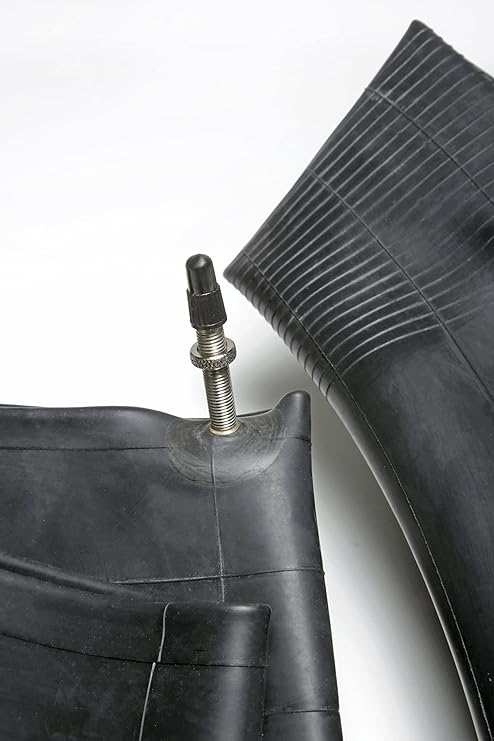 Close-up of a black tire with valve stem on a white background