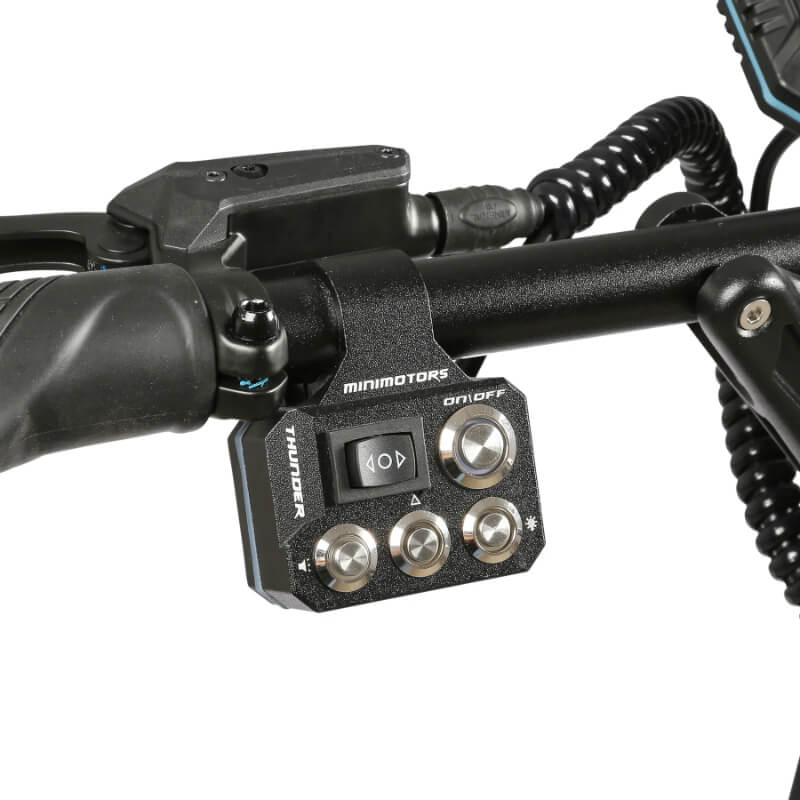 Control panel with buttons and switches on a motorcycle handlebar, featuring the brand 'Minimotors'.