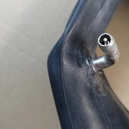 Close-up of a black plastic component with a metal fitting on a neutral background