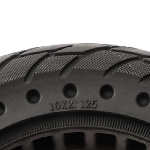 Close-up of a black tire with tread pattern and size marking on a white background