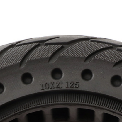 Close-up of a black tire with tread pattern and size marking on a white background