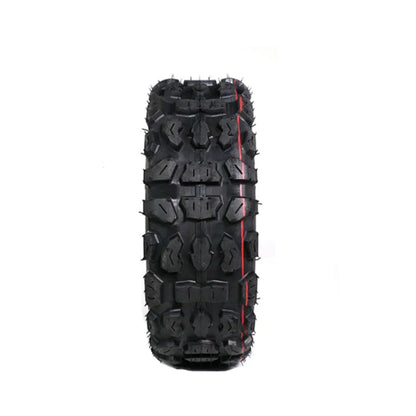 Black off-road tire with prominent tread pattern on a white background