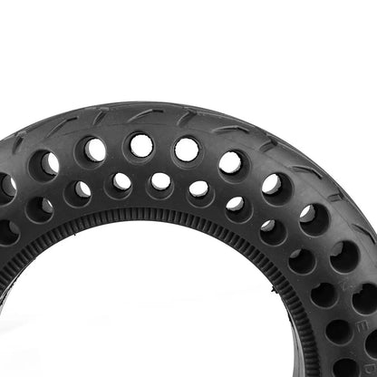 Close-up of a black tire with unique tread pattern on a white background