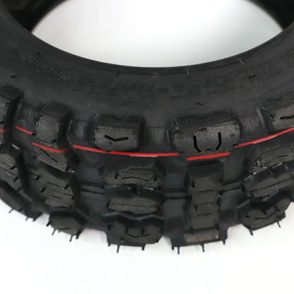 Close-up of a tire with prominent tread pattern on a white background
