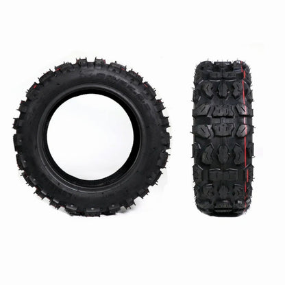Two black off-road tires with tread patterns on a white background
