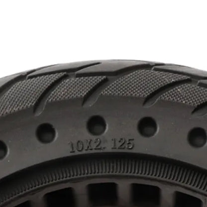 Close-up of a black tire with tread pattern and size marking on a white background