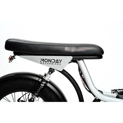 Close-up of a bicycle seat with 'Monday Motorbikes' branding on a white background