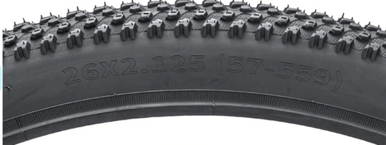 Close-up of a bicycle tire with tread pattern and size marking '26x2.125 (57-59)'.