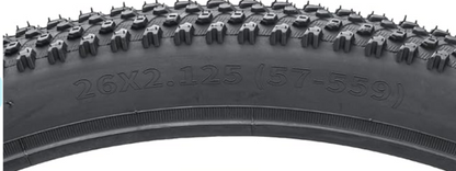 Close-up of a bicycle tire with tread pattern and size marking '26x2.125 (57-59)'.