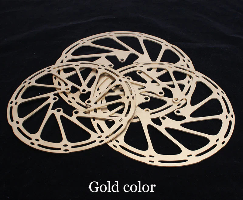 Three gold-colored bicycle disc brakes on a black background