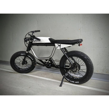 Electric bike with large wheels on a gray floor against a gray wall