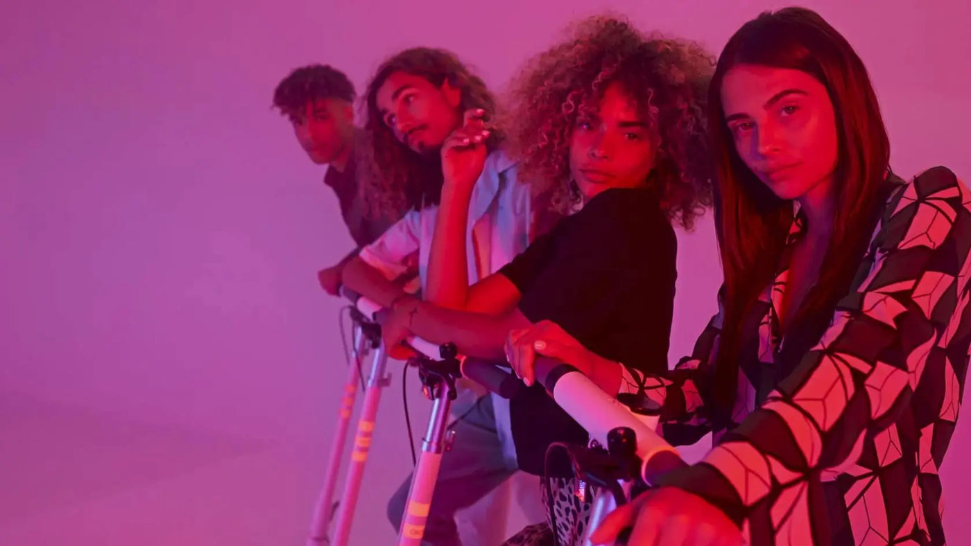 Four people with crutches against a pink background