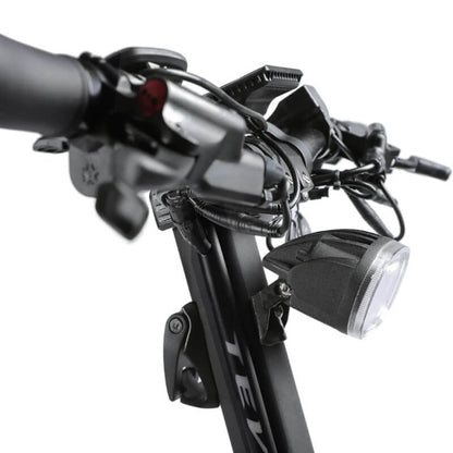 Close-up of a bicycle handlebar with lights and controls on a white background